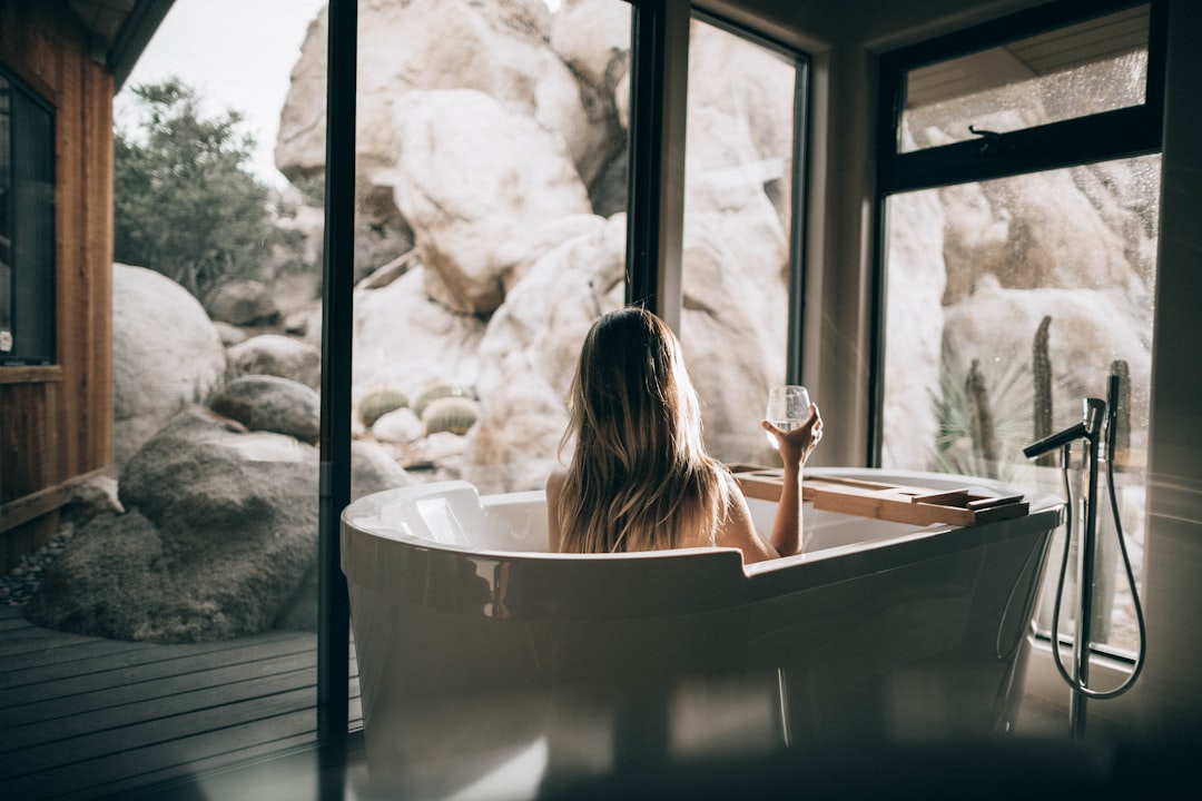 dog body language — woman in white bathtub holding clear drinking glass