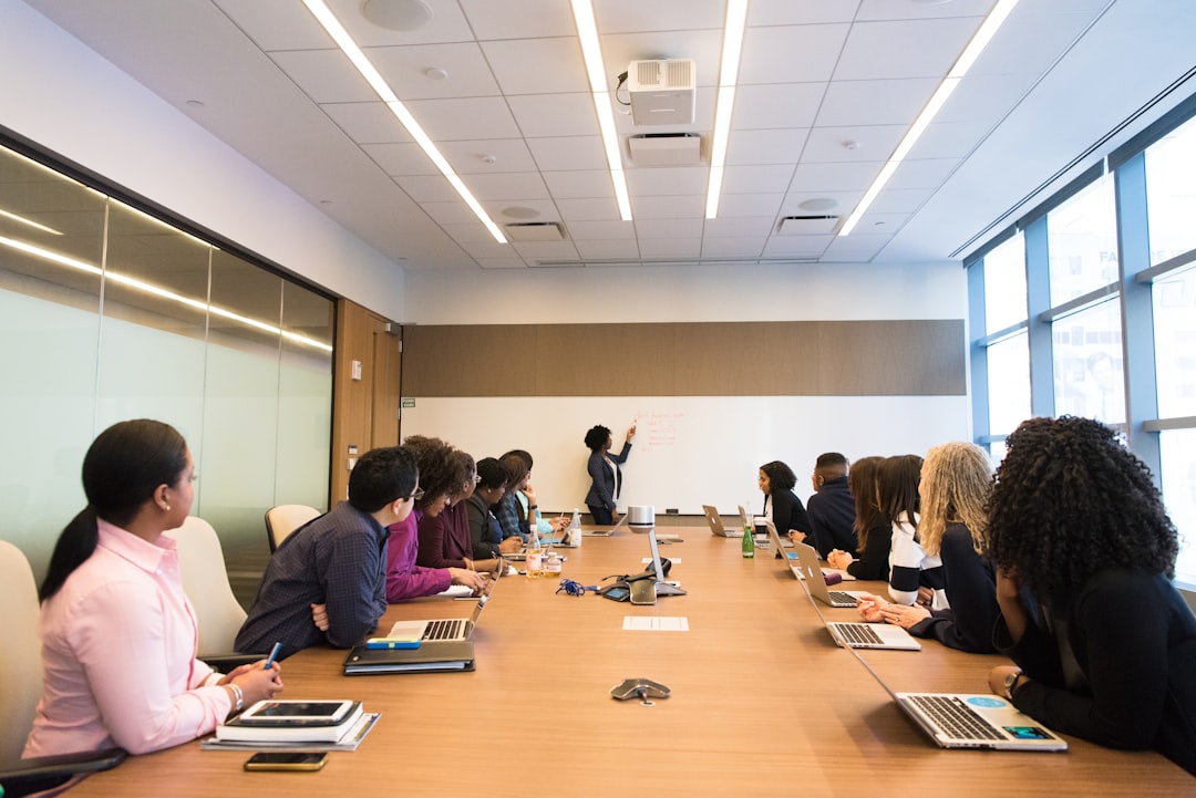 therapy dog organizations — people on conference table looking at talking woman