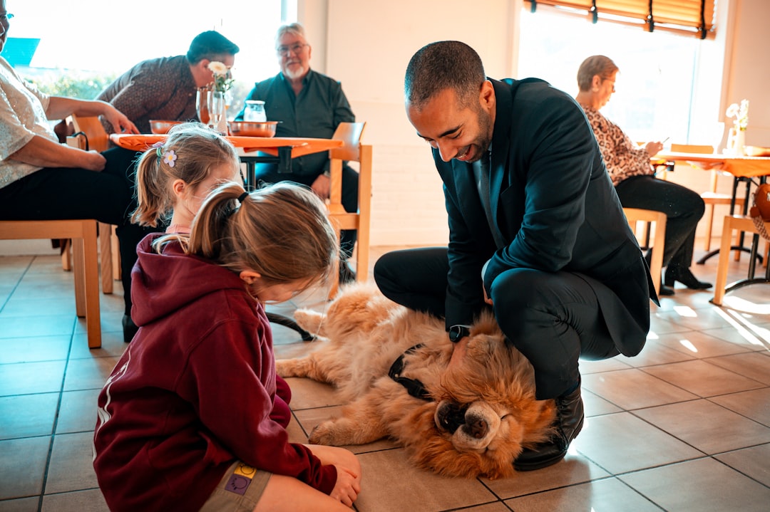 therapy dog temperament test — Man pets a fluffy dog with a child watching