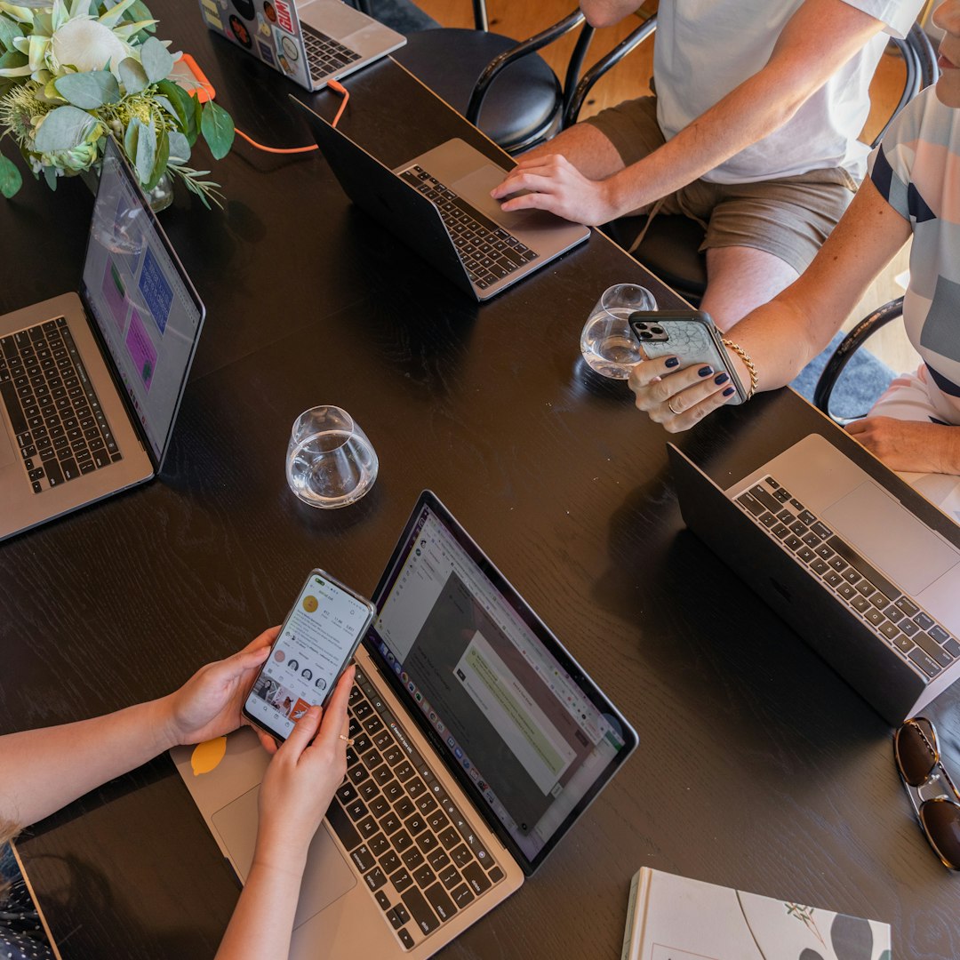 therapy dog program setup — a group of people sitting around a table with laptops